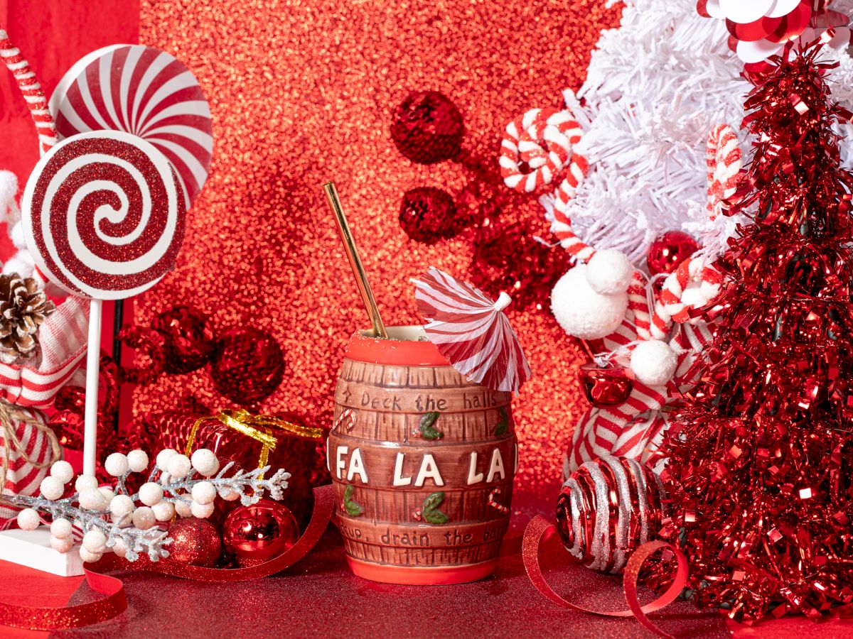 Festive scene with red and white decorations, candy canes, lollipops, a red tree, and a mug labeled 