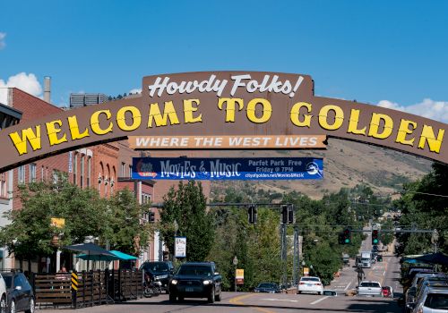 The image features a street scene with a large archway sign that reads 