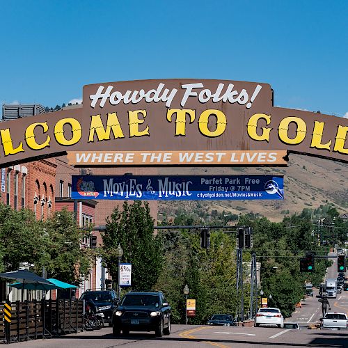 The image features a street scene with a large archway sign that reads 